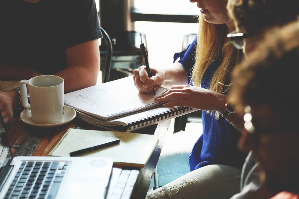 Business planning workspace with documents and laptop, illustrating go-live strategies, client support planning, operational readiness, and project implementation